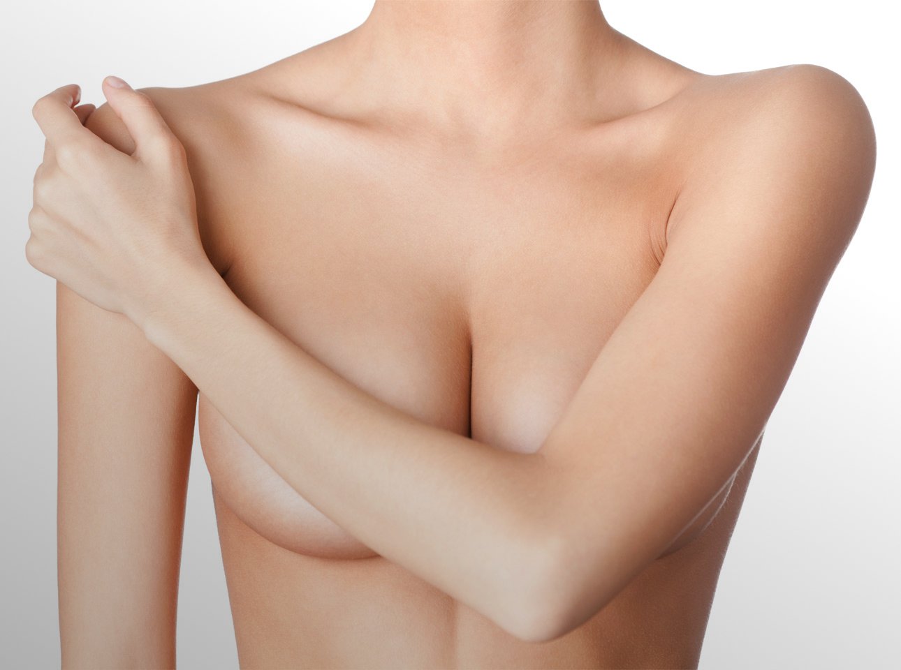 bare chested breast plastic surgery patient model with harm covering her breasts